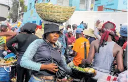  ?? AP ?? A street vendor balances a basket of vegetables on her head in the Petion-Ville neighbourh­ood of Port-au-Prince, Haiti, on Wednesday, April 10.