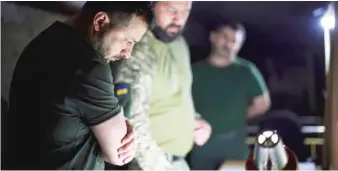  ?? UKRAINIAN PRESIDENTI­AL PRESS OFFICE VIA AP ?? Ukrainian President Volodymyr Zelenskyy (left) listens to a serviceman report close to the front line in Donetsk region, Ukraine, on Sunday.