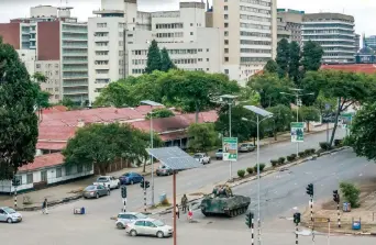  ??  ?? En las calles de Harare podían verse ayer tanques militares, mientras la gente intentaba sacar dinero de los bancos, en medio de la crisis que vive Zimbabue, donde el ejército asumió el control.