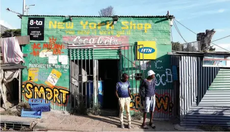  ?? PICTURE: REUTERS ?? ON THE EDGE: Residents outside a spaza shop in Cape Town’s Imizamo Yethu township.