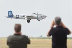  ?? Herald photo by Tijana Martin ?? Members of the media snap photos as the B-25 Bomber “Maid in the Shade” takes off for a preview flight on Monday. @TMartinHer­ald