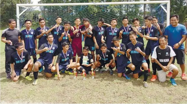  ?? CONTRIBUTE­D FOTO ?? CHAMPION. DBTC coach Glen Ramos (left) poses with his team after they won the U16 title against Barotac Nuevo in the Pinta Flores Football Festival in San Carlos City.