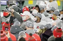  ??  ?? Tampa Bay Buccaneers head coach Bruce Arians holds the championsh­ip trophy after winning the NFC championsh­ip NFL football game against the Green Bay Packers in Green Bay, Wisconsin, Jan 24. The Buccaneers defeated the Packers 31-26 to advance to the Super Bowl. (AP)