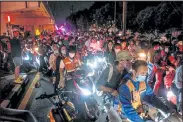  ?? Jack Taylor / AFP ?? Motorcycle taxi riders carrying pro-democracy protesters on Oct. 21 after an anti-government rally in Bangkok.