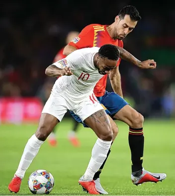  ??  ?? England’s Raheem Sterling (front) keeps Spain’s Sergio Busquets at bay in Seville on MondayNICK POTTS/PA