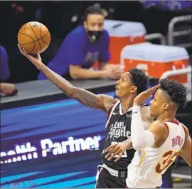  ?? Mark J. Terrill Associated Press ?? THE CLIPPERS’ Lou Williams gets past the Cavaliers’ Isaac Okoro for a shot attempt at Staples Center. Williams started and had 30 points and 10 assists.