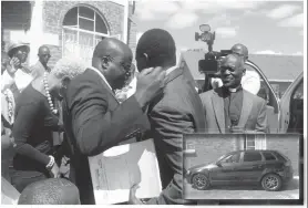  ??  ?? Rev Mhiza (holding file) emotionall­y hugs Mr Maphosa after the presentati­on of a minibus to BICC and a car for his wife. Looking on is the church’s overseer Rev Dube. Inset The brand-new Audi 3 which was donated to Rev Mhizha’s wife