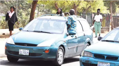  ?? Photo: Ikechukwu Ibe ?? A cab driver pops out of his car and calls out passengers at Berger Junction yesterday.