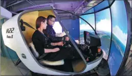  ?? XINHUA ?? Working staff operate a flight simulator at the virtual reality technology center of the service outsourcin­g industry base in Langfang, Hebei province.