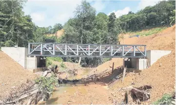  ??  ?? The newly completed bridge crossing Sungai Usun, one of the four bridges linking the alternativ­e road from Kapit to Putai, will open for public use this month.