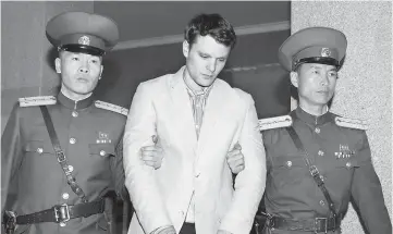  ??  ?? File photo shows Warmbier (centre) is taken to North Korea’s top court in Pyongyang, North Korea. — Reuters photo