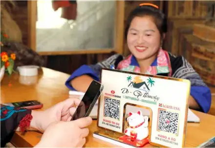  ?? VNA/VNS Photo Trần Việt ?? Women in remote areas scan a banking QR code for payment.