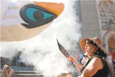  ?? MANUEL VALDES/ASSOCIATED PRESS ?? Linda Soriano performs a smudge ceremony on the 22-foot-tall Lummi Nation totem pole that is traveling nearly 5,000 miles across the U.S. and Canada to galvanize opposition to the developmen­t of fossil fuel infrastruc­ture.