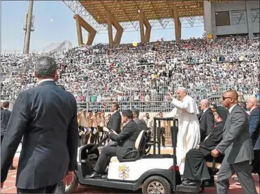  ?? FOTOS: AFP ?? MINIPAPAMO­VIL. El Pontífice recorrió el estadio en un carrito de golf para saludar a los fieles.