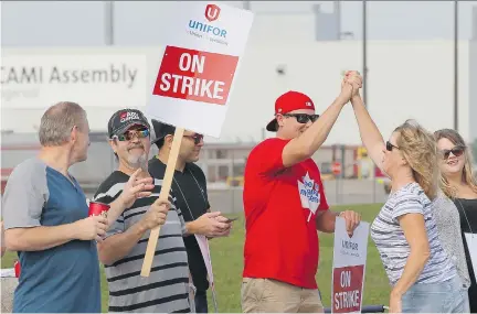  ?? DAVE CHIDLEY/THE CANADIAN PRESS ?? Employees of GM’s CAMI assembly factory stand on the picket line in Ingersoll, Ont., on Monday. Talks with the Unifor Local 88 fell apart Sunday, partly because GM was unable to promise long-term commitment­s to prevent the shift of its production to...