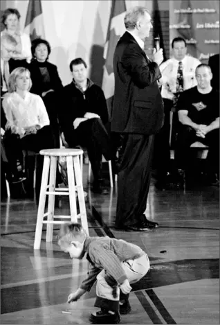  ?? ADRIAN WYLD/ CP ?? A boy zeroes in on a piece of paper as Prime Minister Paul Martin talks about the Liberal daycare plan during a campaign stop in Saint John, N.B., yesterday.