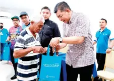  ?? — Bernama photo ?? Abdul Razak presents Chinese New Year goodies to a recipient during the programme.