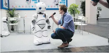  ?? ODD ANDERSEN / AFP / GETTY IMAGES ?? A TV crew interviews a robot Monday at the Tanscorp stand at the Cebit technology fair in Hannover, Germany.