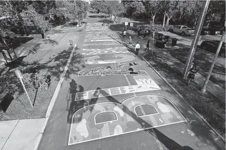  ?? [CHRIS O'MEARA/ THE ASSOCIATED PRESS] ?? Several local artists painted a Black Lives Matter mural on the street during a Juneteenth 2020 celebratio­n, June 19, outside the Dr. Carter G. Woodson African American Museum in St. Petersburg, Fla.