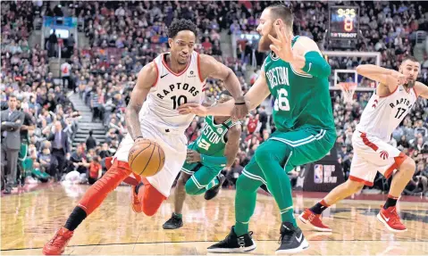  ?? AP ?? Raptors guard DeMar DeRozan dribbles the ball as Celtics centre Aron Baynes defends during the second half in Toronto.