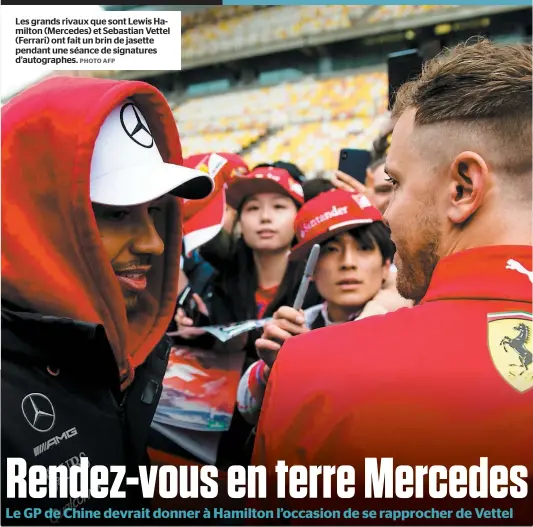  ?? PHOTO AFP ?? Les grands rivaux que sont Lewis Hamilton (Mercedes) et Sebastian Vettel (Ferrari) ont fait un brin de jasette pendant une séance de signatures d’autographe­s.