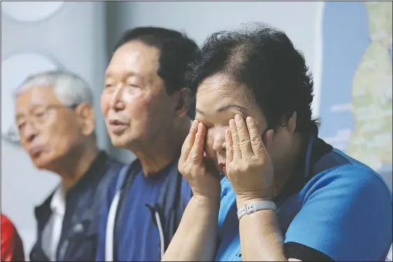  ?? (AP/Ahn Young-joon) ?? Shin Yun-sun (right) wipes her tears at her house in Seoul, South Korea. The thousands of husbands and fathers who never returned from Sakhalin after eight decades is a largely forgotten legacy of Japan’s brutal rule of the Korean Peninsula before the end of World War II.