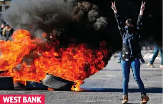  ??  ?? In flames: A protester gestures near burning tyres in Ramallah yesterday WEST BANK