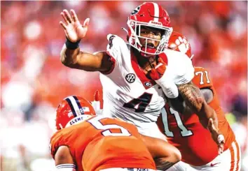  ?? GEORGIA PHOTO BY TONY WALSH ?? Georgia outside linebacker Nolan Smith closes in on Clemson quarterbac­k D.J. Uiagalelei during the Duke’s Mayo Classic on Saturday night at Bank of America Stadium in Charlotte, N.C. Georgia sacked Uiagalelei seven times.