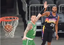  ?? JOE CAMPOREALE/USA TODAY SPORTS ?? Suns forward Mikal Bridges (25) watches as he makes a three-pointer against Celtics center Daniel Theis (27) on Sunday.