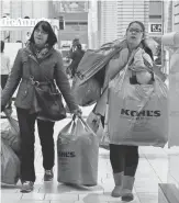  ?? KENA BETANCUR, GETTY IMAGES ?? Customers carry shopping bags at the Newport Mall during Black Friday sales last year in Jersey City.