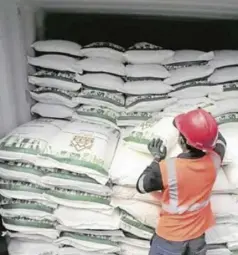  ?? ?? A port worker examines a shipment of sugar.