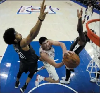  ?? MATT SLOCUM — THE ASSOCIATED PRESS ?? Sixers forward Ersan Ilyasova, center, drives for a shot between Brooklyn’s Jarrett Allen, left, and DeMarre Carroll Friday night. Ilyasova is one of a corps of veterans who can help even out the swings in form from the Sixers’ young nucleus once the...