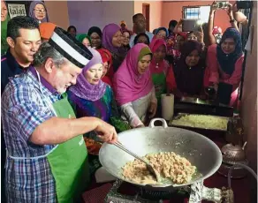  ??  ?? Sultan Ibrahim cooking fried rice for flood victims in Segamat, Johor, on Jan 4, 2016.