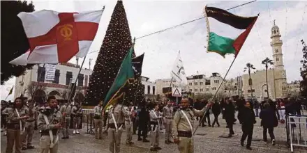  ?? AFP PIC ?? Palestinia­n Christian Scouts performing at the Manger Square outside the Church of the Nativity in Bethlehem yesterday.