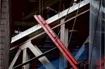  ?? JONATHAN WIGGS/GLOBE STAFF ?? Workers looked to secure a beam that fell from above South Station on Wednesday.