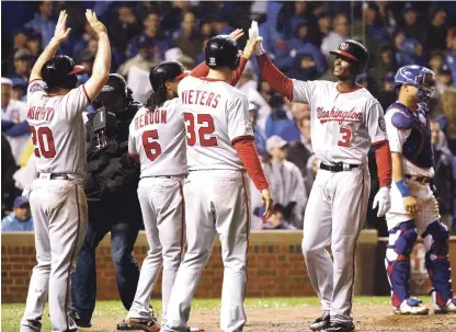  ??  ?? Michael Taylor, de los Nacionales de Washington (derecha) es felicitado por sus compañeros de equipo después de batear un grand slam durante la octava entrada.