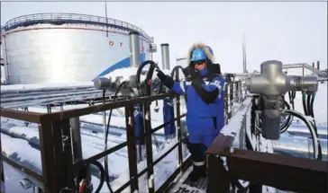  ?? ANDREY GOLOVANOV/AFP ?? An employee of Russian gas and oil giant Gazprom works at the Novoprtovs­koye oil and gas condensate­s oilfield at Cape Kamenny in the Gulf of Obt, 250 kilometres north of Nadym in northern Russia, in February 2015. With its oil output at record levels...