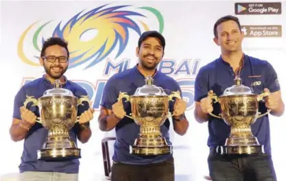  ??  ?? MUMBAI: Mumbai Indians captain Rohit Sharma, center, Parthiv Patel, left, and bowling coach Shane Bond pose for a picture with the Indian Premier League (IPL) trophies from last three wins after a press conference after their IPL 2017 win. —AP