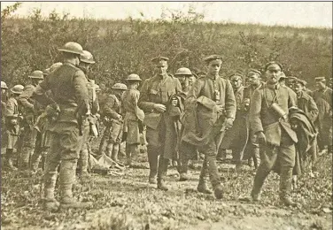  ?? (Courtesy Photo/U.S. Army Signal Corps) ?? This photo provided by U.S. Army Heritage and Education Center has been cropped in to show a closer view of American soldiers with German prisoners in northern France during WWI on Sept. 26, 1918.