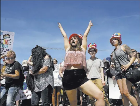  ?? Christian K. Lee Las Vegas Review-Journal @chrisklee_jpeg ?? Rally participan­ts listen to music from the Phenomenau­ts, a science rock band, during the local March for Science at Art Square parking lot on Saturday.