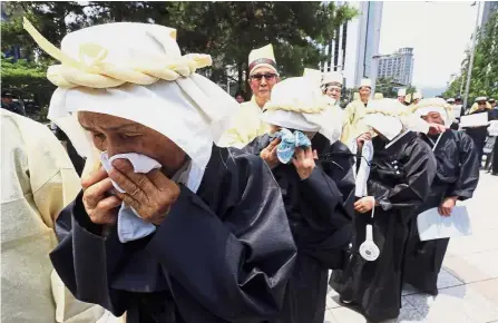  ?? — AP ?? Tears for the fallen: Family members of late Korean War veterans weeping during a ceremony in Seoul to mark the 68th anniversar­y of the war.