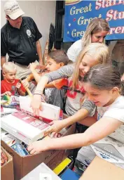  ?? [PHOTOS BY PAUL HELLSTERN, THE OKLAHOMAN] ?? Tinker Elementary School students look through school supplies donated by the Support Our Schools project in Midwest City.