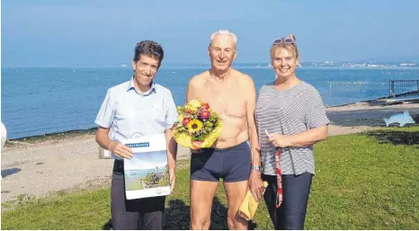  ?? FOTO: GEMEINDE ?? Frank Jost, Leiter der Tourist-Informatio­n Langenarge­n und Schwimmmei­sterin Coretta Deeg freuen sich mit Herrmann Fischer (Mitte).