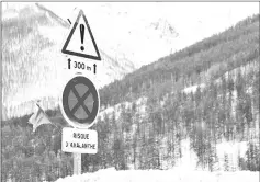  ?? – Reuters photo ?? Road signs are pictured on a snow-covered road in Saint-Pancrace, France. The sign on the bottom reads, “Avalanche risk”.