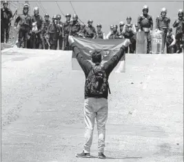  ?? George Castellano­s AFP/Getty Images ?? OPPOSITION ACTIVISTS clash with police during a protest last week in San Cristobal. Maduro’s approval ratings have dropped as low as 15%.