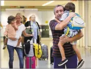  ?? JULIE JACOBSON — THE ASSOCIATED PRESS ?? Juan Rojas, right, of Queens hugs his 4-year-old grandson Elias Rojas, as his daughter-in-law Cori Rojas, left, carries her daughter Lilly, 3, in the terminal at Kennedy Airport in New York after Cori Rojas arrived Tuesday from San Juan, Puerto Rico....