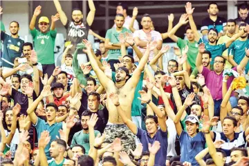  ?? — AFP photo ?? Supporters of Al-Ahly Tripoli cheer for their team during the CAF Champions League quarterfin­al first-leg football match between Libya's Al-Ahly Tripoli and Tunisia's Etoile du Sahel at Borg Al-Arab Stadium near Alexandria on September 17, 2017.