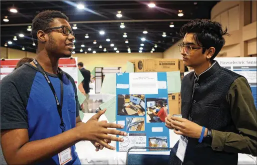  ?? PHOTOS CONTRIBUTE­D BY CHRISTINA MATACOTTA ?? Quincy Sanders (left) and Jay Raval present their STEM projects Feb. 21 at the Gwinnett County Regional Science, Engineerin­g + Innovation Fair in Duluth. Projects involved solving problems such as reducing phosphorus in Lake Lanier, protecting bees and other pollinator­s and maintainin­g healthy soil.