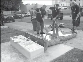  ?? Special to the Democrat Gazette ?? Secretary of state workers start cleanup Wednesday around the smashed Ten Commandmen­ts monument that was just installed on Tuesday. State Sen. Jason Rapert, who called on elected officials to take a stand against violence and against people “using...
