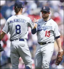  ?? Associated Press ?? SEASON SWEEP
Los Angeles Dodgers first baseman Max Muncy (13) and third baseman Zach McKinstry (8) celebrate after defeating the Washington Nationals 5-1 on Sunday in Washington. The Dodgers swept all seven games in the season series with the Nationals. They also won their ninth straight.